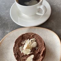 Vegan and raw cheesecake with tasty coffee  at The Optimist Co in Izmir