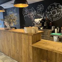 Interior, has barstools and small bar along wall not shown, two small cushioned seats   at VegAmazing Doughnuts - Tirso de Molina in Madrid