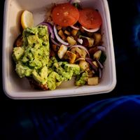 Avocado toast with potatoes topped with purple onions and tomatoes at First Watch in League City
