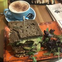 Pineapple smoothie, oat cappuccino and vegan sandwich (rocket, hummus, avocado, tomato)  at La Mala Brunch - Setas in Sevilla