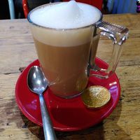 Oat milk latte - the coin is not vegan (December 2022) at Georgie Porgie's at Beautifully Bonkers in Builth Wells