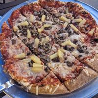 Pineapple and mushroom pizza on hand tossed thin crust at Glass Nickel Pizza Co in Appleton