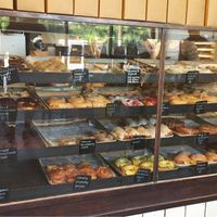 Vegan options marked with a V on labels as well as on the wall behind the cashier  at Revolution Doughnuts in Decatur