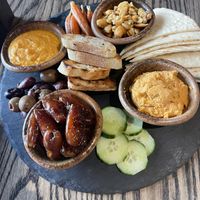 MEZEH 
marinated olives, roasted carrots, hummus, apricot glazed cashews, cucumbers, dates, grilled flatbread  at Carabiner in Big Sky