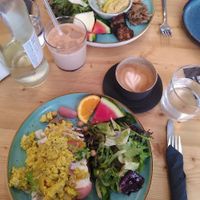 Breakfast with vegan scrambled tofu on delicious bread, a side salad with pickled radishes and slices of fruit at schnack in Mainz