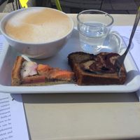 coffee with oat milk and 2 little slices to try. delicious! at Deli Kitchen in Munich