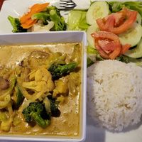 Veggie coconut curry with steamed vegetables and a garden salad at Swings Restaurant & Bar in San Pedro