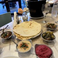 Snack optiones are different hummus and pickles and olives and pita breadd  at Dubai Comidas Árabes in Salta