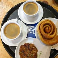 Americano coffees, cinnamon bun and breakfast cookie at Doppio Coffee Warehouse Kentish Town in North West London
