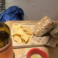 Jackfruit burrito and kombucha bottle in foreground  at Gallo Santo in Barcelona