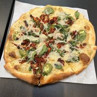 Build your own pizza with vegan artichoke sauce, vegan cheese, sun dried tomatoes, jalapeños, and spinach.   at 2 Guys Pies Brick Oven Pizza in Yucca Valley
