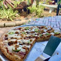 Millet Flax dough topped with jalapeño, mushrooms, tempeh sausage (recommended), and Miyokos vegan cheese.  at Satchel's Pizza in Gainesville