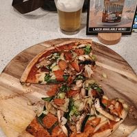 Vegan pizza and beer. Cheese underneath as is best on a vegan pizza! at Outback Bar And Grill in Coober Pedy