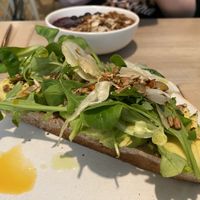 Avocado on toast with granola bowl in background   at British Patagonia in North London