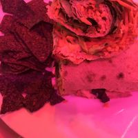 Vegan Wrap (sat near red Christmas lights, so this picture is due to the red color of lights, food looks yummier in person; the diced carrots look like cheese in this picture) at Green Erth Bistro in Jacksonville