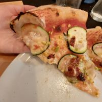 Esta es una foto de la Michella con mozarella vegana. Salsa de tomate, calabacín, tomate seco y pistacho que se añade después de ser horneada at Gorlomi Pizza in Pontevedra