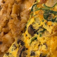 Omelette with mushrooms, onion, & spinach + vegan cheese. Very generous amount of mushrooms. Potatoes were cooked to perfection. Absolutely fantastic! at The Local's Spot in Egg Harbor