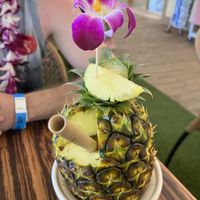 a mango vegan drink in a pineapple.   at Polynesian Cultural Center in Laiea