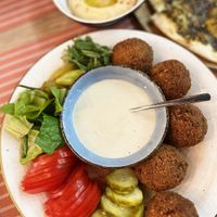 Falafel plate w/fresh vegetables, pickles and tahini sauce. Note that tahini sauce in falafel plate can be made with dairy, ask to make it vegan. at Byblos Grill Bakery Restaurant in Yerevan