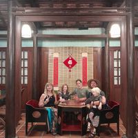 Sitting at the 100 year old table all 6 of us very full after a great dinner! at Muro Organic Vegan Restaurant in Nha Trang