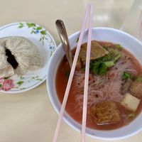 Steamed oat BBQ bun and Thai style noodles with pink tofu saucee  at Sutunthip Vegetarian Food in Bangkok