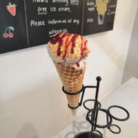 Banana caramel, dark choc cherry, cherry sauce and honeycomb in a standard cone at Lick in Bakewell