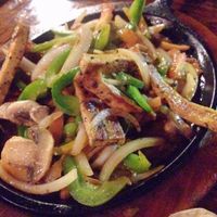 The sizzling half of the vegan fajitas with tofu. at Pokez in San Diego