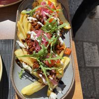 Fake Italian - tofu bolognese, served on fries with tomato salsa, pickled red onions, garlic sauce, and vegan Parmesan  at Soul Kitchen in Dubrovnik