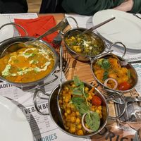 selection of curries. left: vegetable korma. top middle: vegan sag no paneer. bottom middle: chana masala. right: bombay alo  at Vegan India - Gloucester Rd in Bristol
