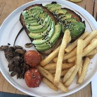 Avocado toast with a side of roasted tomatoes, mushrooms, and fries  at Cafe McKenzie in Randwick