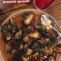 Crispy Brussels sprouts/red onions tossed in a tangy, sweet & lightly spicy sauce w pecans and dried cranberriess  at The Ginger Mule in Houston