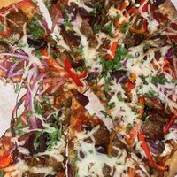 Supreme pizza: marinara, mozzarella, plant based sausage, mushrooms, red bell peppers, red onions & olives  at The Ginger Mule in Houston