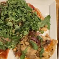 Pizza is stacked with vegetables  at Candle in New York City