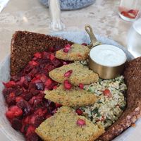 Foreground: red hummus mezze bowl with falafel. Background: vegan boss bowl. at One Nation in Munich