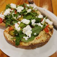 Tostada vegana(Hummus, pepino, tomate, queso vegano en pan de masa madre). at Pionero Coffee Roasters in Oviedo
