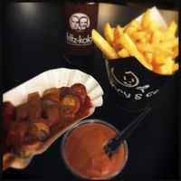 Scalded organic bratwurst in spicey sauce and fries at Curry Co in Leipzig