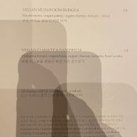 Very poor photograph of the vegan menu.  It says:  Vegan Mushroom Burger and Vegan Ciabatta Sandwich   at Cafe One -  JW Marriott Seoul in Seoul