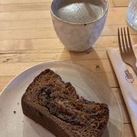 Freshly baked banana bread with chocolate chips (still warm from the oven), and a black sesame latte   at Palm Greens & Soul in East London