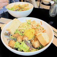 Rice noodle and carrot, peanut satay tofu, green salad, and edamame salad with bread and dip  at salarte in Munich
