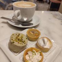 Cappuccino con latte d'avena e pasticcini con: mousse al pistacchio, panna al lime, cioccolato bianco e pepe rosa, lemon curd e crema di arachidi, caramello salato e cioccolato. at Nepá in Milan