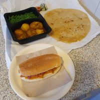 Vegan roti dish for take away with long beans and potatoes in masala and a vegan pom sandwich at Fawaka in Nijmegen
