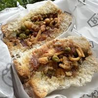 Samosa Chaat Vegan Sandwich 🌱 White Bloomer with Smashed Samosa, Tamarind Chutney, Tomato, Green Chilli Sauce, Bombay Mix (Bought to take away)  at Rack in Stockport