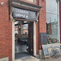 Door and facade of the board game cafe, featuring a pride flag at Common Meeple Board Game Cafe in Swansea