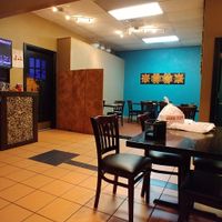 View of side seating along with entrance to an eating room that is enclosed with windows and a door at Kesari in Plano