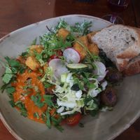 Saturday brunch plate with fried tofu bites, caesar salad, pesto potatoes and giant beans and eggplant on a bell pepper sauce with salad, greens and pea spread. Heavenly! at Ravintola Lohtu in Helsinki