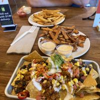 Southwestern Nachos and fries! His burger is coming out soon!  at Next Level Veggie Grill - University Village in Seattle