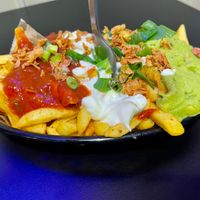HOLY GUACAMOLE: Frietjes met guacamole, vegan sour cream & tomaten.  at XONI STREETFOOD in Tielt