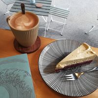 Belgische heiße Schokolade (Zartbitter mit Hafermilch) und Kuchen mit Mohnboden, Waldbeerkompott und Pistazien-Sojasahne-Creme at Pustekuchen in Ludwigsburg