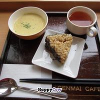 A brown rice triangle with crushed sesame seeds on the side, some soup, and some tea. at Genmai Cafe in Osaka