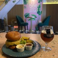 The Satiba house burger with lentil patty, and “not-cheese” served with side fries, paired with an American red ale beer.   at Satiba Therapy Coffee Shop in Arequipa